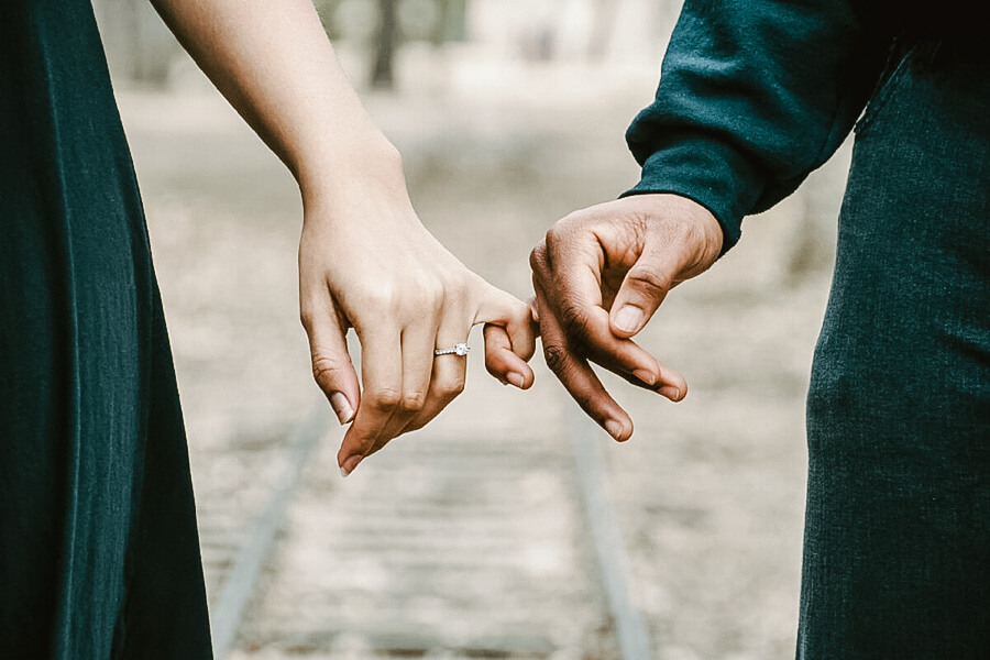 woman and man holding hands with fingers